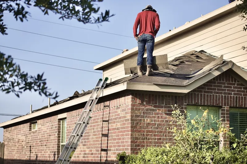 Professional roofer working on a residential roof in Roy